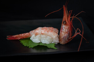 Ama-ebi nigiri sushi on black background.