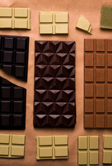 Different types of chocolate bars on craft paper. View from above