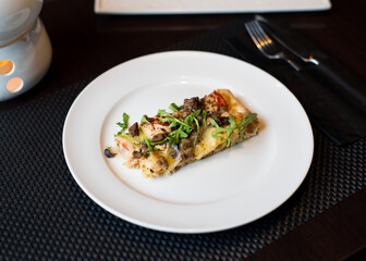 slice of pizza on a white plate in a cafe