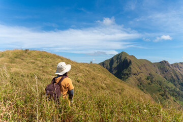 happy woman hiking on top mountain at Khao Chang Phueak, Thongphaphoom National Park, Kanchanaburi Province, Thailand. Subject is blurred, noise and color effect.