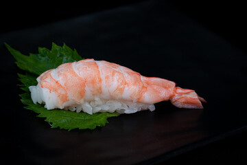 Nigiri sushi with shrimp isolated on black background.