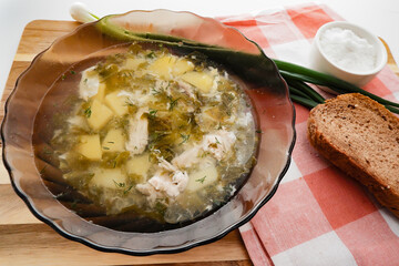 soup of sorrel, green onions and eggs is poured in a plate