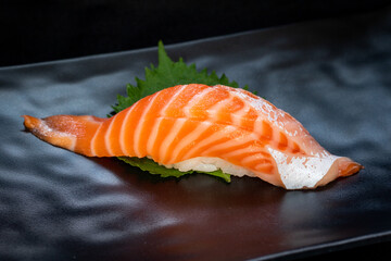 Delicious Sushi Nigiri with Salmon (Sake) on black background. Traditional Japanese cuisine.