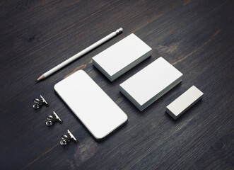 Smartphone, blank business cards, pencil and eraser on wood table background. Blank branding mockup.