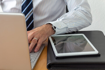 Businessman ist working in Homeoffice on his Laptop and preparing a Meeting