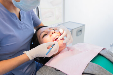 Young female dentist performed dental procedure to a female patient.