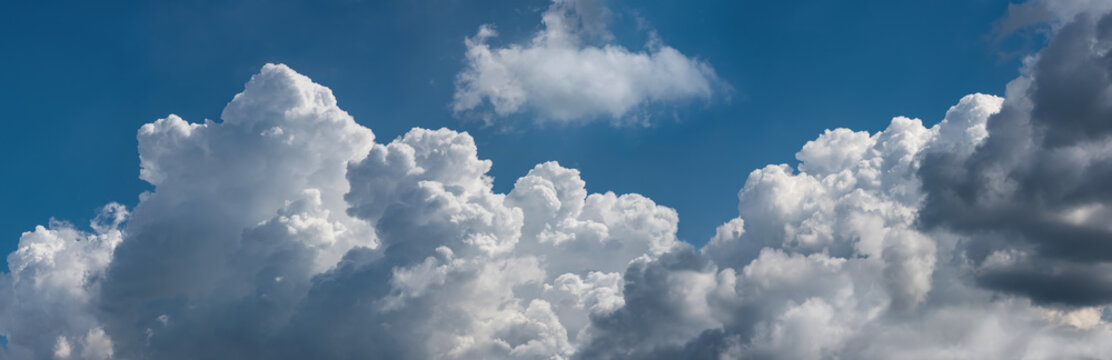  Beautiful cumulus clouds against the blue sky.. Panoramic shot of a cloud cluster. Wide format.
