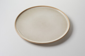 Circular clean generic pottery plate in a neutral beige