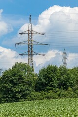 High voltage electric pylon against cloudy blue sky. Electricity distribution. Energy concept. Alternative energy.
