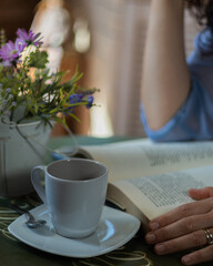 Mujer tomando café y leyendo un libro 