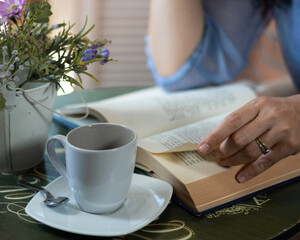 Mujer tomando café y leyendo un libro 