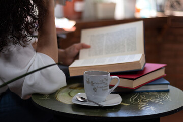 Mujer tomando café y leyendo un libro 