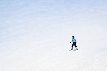 Fototapeta na wymiar Young caucasian Teenager boy with no jacket skiing down hill on ski slope