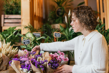 Young businesswoman choosing a bouquet in her flower shop.