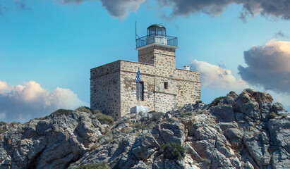 Lighthhouse building on a rocky cliff. Ios island Greece.