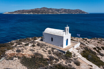 Greece Kimolos island, Cyclades. White small church at Psathi port, aerial drone view.