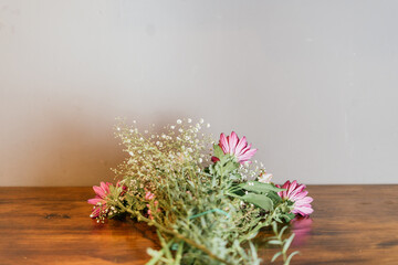 Bouquet of flowers in preparation on a wooden work table.