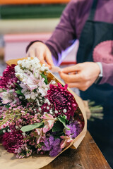 Obraz na płótnie Canvas Detail of hands finishing preparing a bouquet of flowers.