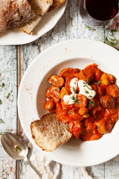 A bowl of sausage goulash served on a rustic table