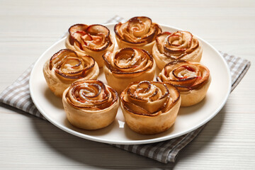 Freshly baked apple roses on white wooden table. Beautiful dessert