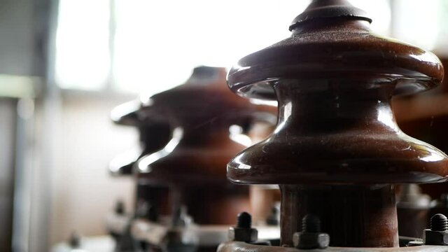 close-up of ceramic electrical insulators of high voltage power poles or electrical supports.