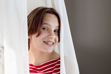 Dental metal braces on the teeth of a young girl, she poses for a photographer after installing braces at the dentist