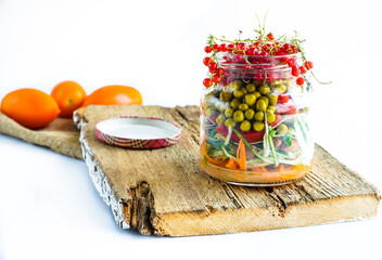 A snack of raw vegetables in a glass. Bright vegetables on a white background
