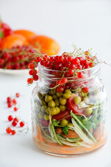 A snack of raw vegetables in a glass. Bright vegetables on a white background