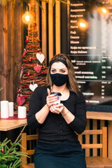 Precautions in the public places after quarantine ended. Young woman with medical mask in cafe