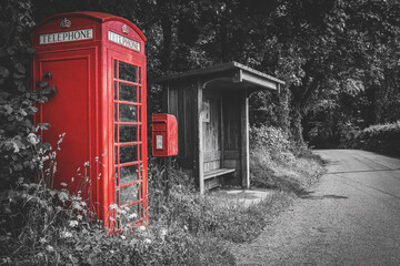 Traditional red British telephone booth, post box and wooden bus stop, selective color on black and...