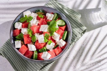 Summer salad with watermelon, mint, cucumber and feta cheese close up. Shadows