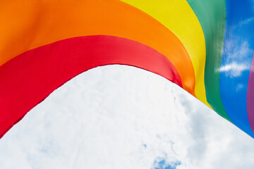 bottom view of colorful lgbt flag against cloudy sky