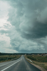 asphalt track road with a stormy dark sky background. empty track with black clouds