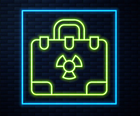 Glowing neon line Radiation nuclear suitcase icon isolated on brick wall background. Vector
