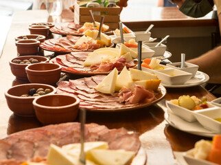 Portuguese cheese, ham and salami boards being prepared at the counter table