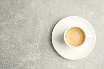 Cup of hot aromatic espresso on light table, top view. Space for text