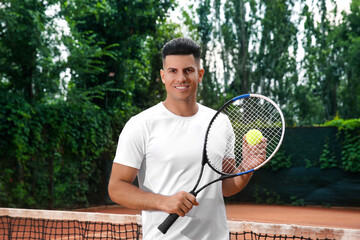 Man with racket and ball on tennis court