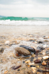 Stones on beach with wave in background