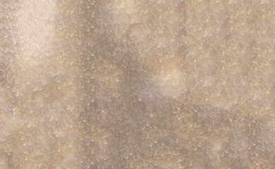 The surface of the dirty window glass, covered with dusty traces of raindrops. Blurred yellow...