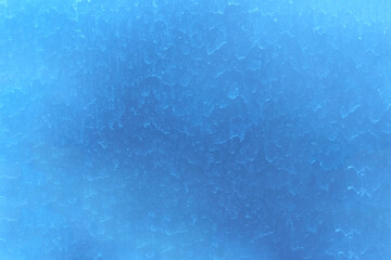 Fototapeta na wymiar The surface of the dirty window glass, covered with dusty traces of raindrops. Blue blurred abstract texture.