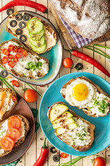 composition: sandwiches with vegetables, salmon and egg, on a wooden background, proper nutrition, top view