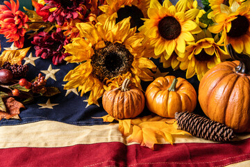 autumn orange pumpkins and yellow sunflowers on American flag