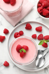 Delicious raspberry mousse with mint on white marble table, flat lay