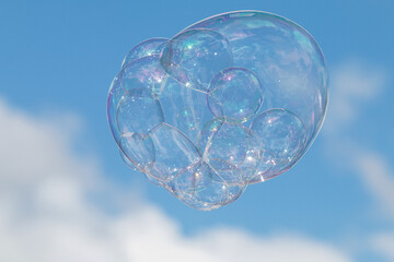 Large Soapy Bubble Floats Against Blue Sky Background