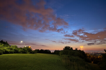 Fototapeta premium Beautiful wide angle view of very rare noctilucent clouds and common clouds seen in Dublin, Ireland on July 12, 2021 a half of hour before midnight. Details of NLC. Night shining clouds. Crescent Moon