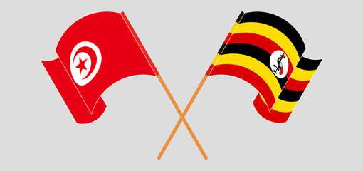 Crossed and waving flags of Tunisia and Uganda