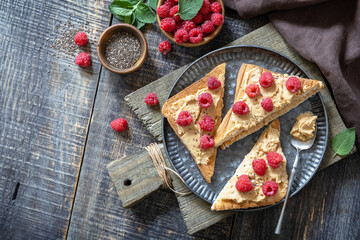 Summer sweet dessert sandwich breakfast. Tasty toasted with peanut butter and raspberry on a rustic wooden table. Copy space.