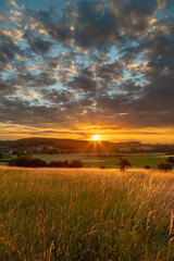 Obraz premium Long exposure image of an amazing sunset over the valley in Maastricht with a dramatic sky, showing amazing colors and impressive landscape views with on a view of Devils cave a former quarry