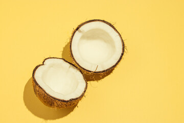 Coconut and two halves, on a yellow background, summer