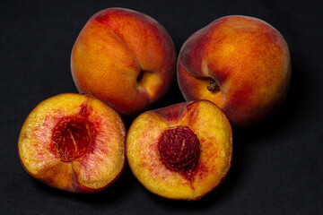 Fototapeta na wymiar Peaches on a black background. Peach cut in half. Healthy diet.